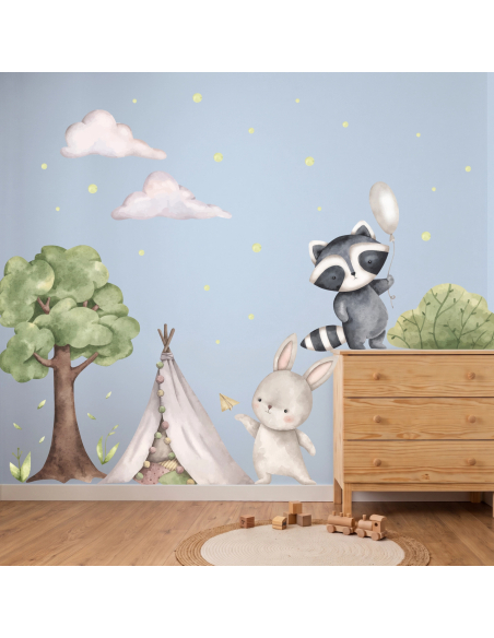Adesivi murali con procione, coniglietto, albero e tenda indiana in stile acquerello applicati in una cameretta per bambini.
